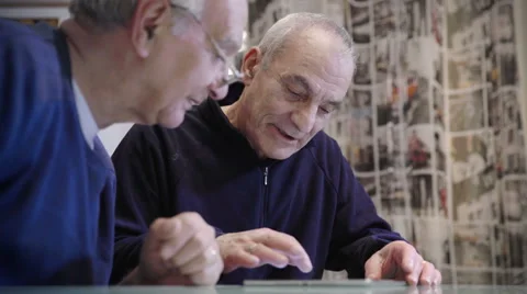 Seniority and technology: old man explains to his friend how to use tablet Stock Footage 63385908