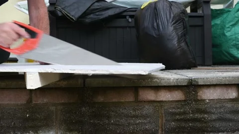 SeniorMale hands cutting through Plaster board in garden for home improvments 스톡 동영상 140736743