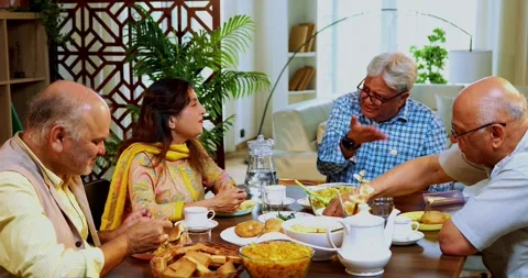 Seniors chatting while having food and laughing during a cheerful friendly meal Stock Footage 342386012