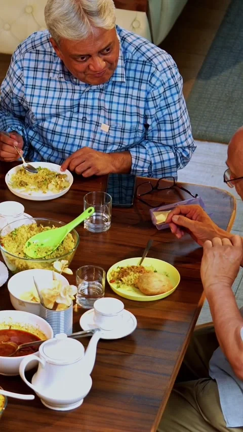 Seniors chatting while having food and laughing during a cheerful friendly meal Video stock 342387155
