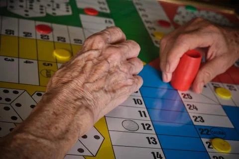 Seniors hands playing board game Stock Photos