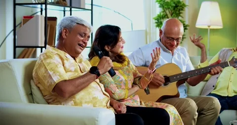 Seniors singing while playing guitar together during indoor musical reunion Stock Footage 342386919