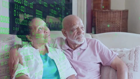 Seniors sitting on sofa watching offscreen tech, leaning, smiling while green Stock Footage 333574871