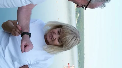 Seniors talking by the lake using a smart watch. Sports training after Stock-Footage 250111199