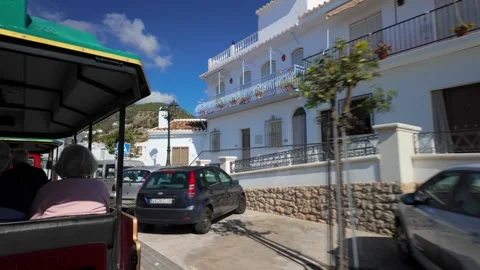 Seniors on tour guided train bus going through village, Frigiliana, Spain - 4K Video stock 340042613