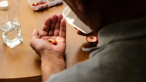 Senoir man Taking Pills and Drinking a Glass of Water Close up Stock Footage 157758564