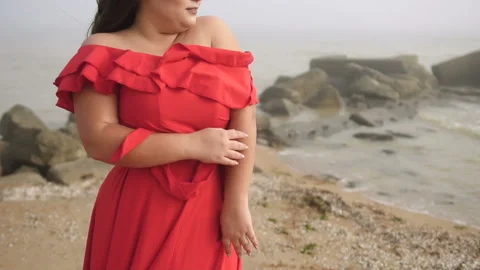 Sensitive beautiful plus size model at the beach in red dress Stock Footage 110850374