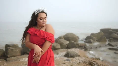 Sensitive beautiful plus size model at the beach in red dress Stock Footage 110850656