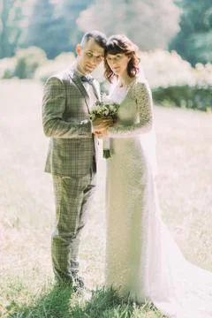 The sensitive full-length portrait of the smiling newlyweds in the park. Stock Photos