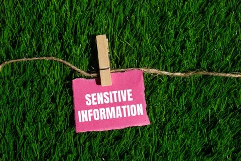 Sensitive information message written on ripped torn pink paper piece with gr Foto stock