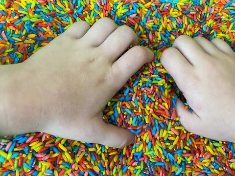 Sensory development in children. Colored rice for sensory development Stock Photos