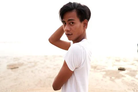Sensual asian man looking to the camera in front of the sea Stock Photos