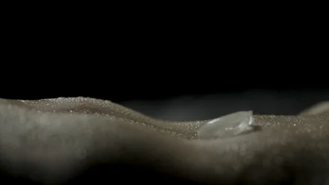 Sensual close-up of an ice cube dropped onto a naked woman's belly button Stock Footage 102839422