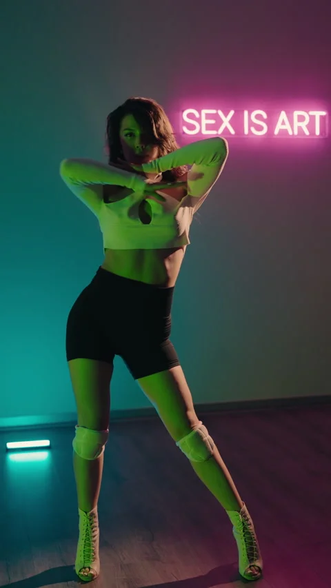 Sensual Dance Performance in Neon Lit Studio. Young Woman Dancing Sensually Stock Footage 342806558