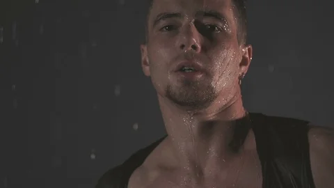 Sensual man in falling drops of water. Slow motion Stock Footage 105679322