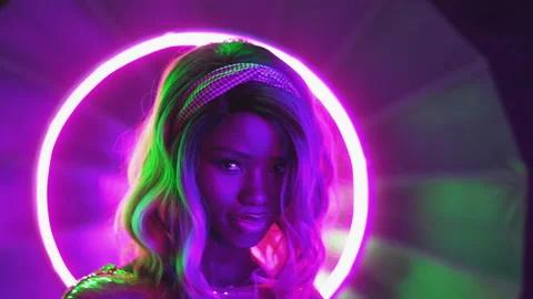 Sensual model posing in neon lights dancing on camera. African American girl Stock Footage 131636203