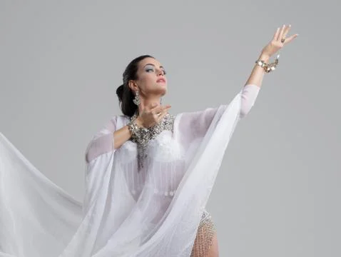 Sensual oriental belly dancer performance on gray studio background Foto stock