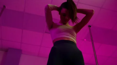 Sensual pole dancer performing in pink neon light Stock Footage 326321557