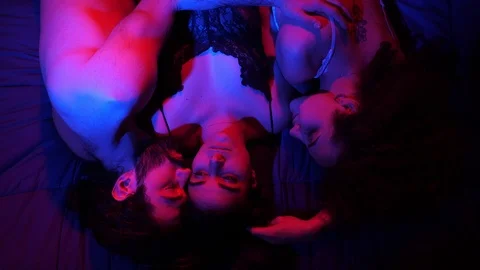 Sensual three people lying on bed kissing.Polygamy,attaction,love Stock Footage 103588825