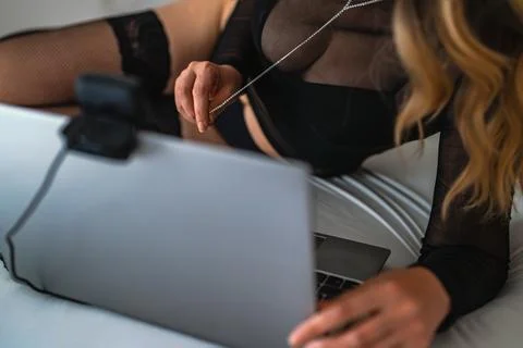 Sensual webcam model performing live stream on laptop. Фото