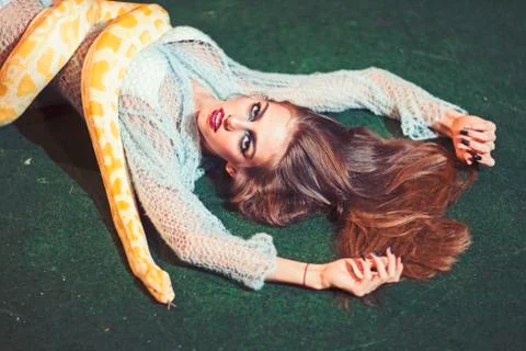 Sensual woman relax with albino python. Snake crawl on woman with long hair Photos