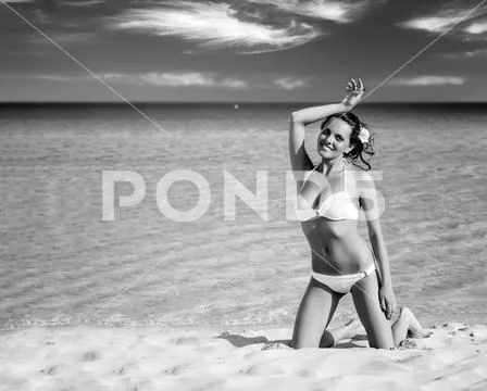 Sensual woman in white bikini sitting on the beach Stock Photos