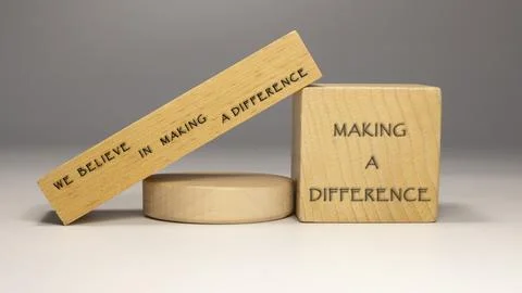 The sentence We believe in making a difference was written. Wooden concept st Stock Photos