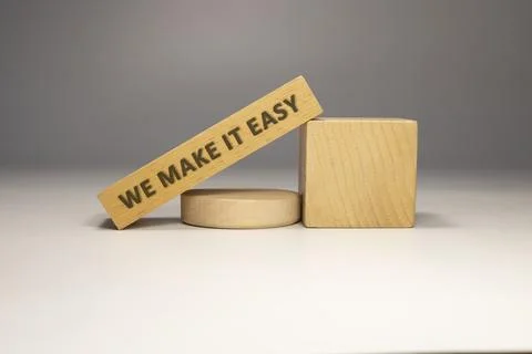 The sentence We make it easy was written. Wooden concept studio shoot. Stock Photos