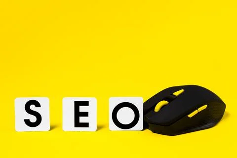 SEO and computer mouse on a yellow background, Search Engine Optimization. Stock Photos