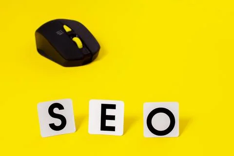 SEO and computer mouse on a yellow background, Search Engine Optimization. Stock Photos