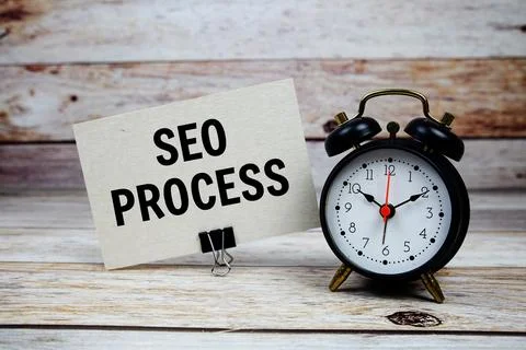 SEO Process text on paper card with alarm clock on wooden background Stock Photos