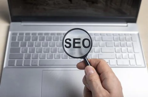 SEO, search engine optimization concept. Word through magnifying glass Stock Photos