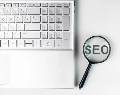SEO, search engine optimization concept. Word through magnifying glass Stock Photos