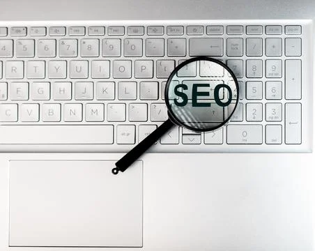 SEO, search engine optimization concept. Word through magnifying glass Stock Photos