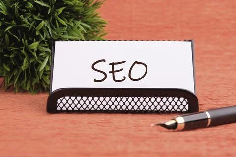 SEO Search Engine Optimization symbol on a white business card on an orange.. Foto stock