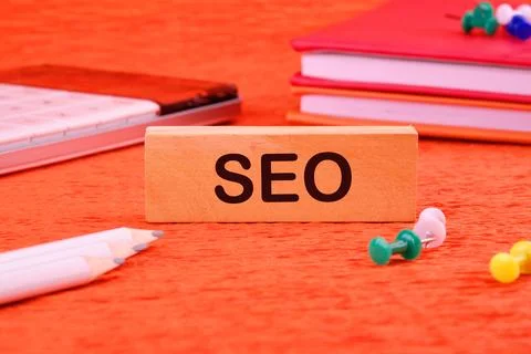 SEO Search Engine Optimization symbol on a wooden block next to office suppli Foto stock