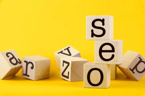 SEO, search engine optimization, text wooden cube blocks on yellow background Stock Photos