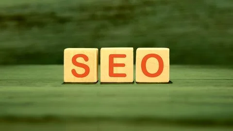 SEO Search Engine Optimization text on wooden cubes on green saturated backgr Stock Photos