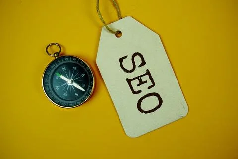 SEO Search Engine Optimization text on price tag with compass on cork board.. Stock Photos