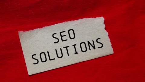 Seo solutions message writing on ripped torn paper piece on red background Stock Footage 283731477