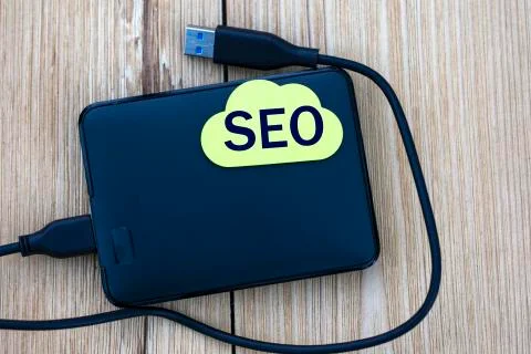 SEO - word on a note sheet lying on an external drive on a wooden background Stock Photos