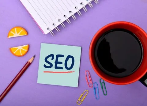 SEO wrriten on notepad Closeup with Cup of Tea Stock Photos