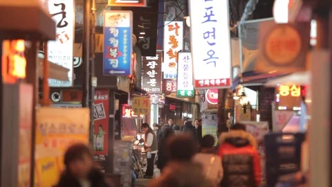 Seoul sci fi backstreet with glowing neon signs and pedestrians 2 Stock Footage 100594297