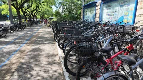 SEP.14.2026.CHINA.Line of Parked Bicycles along Brick Sidewalk Wall Stock Footage 345470788