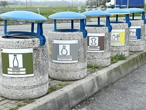 Separate sorting of garbage in Italian freeway parking lot. Stone containers Foto stock