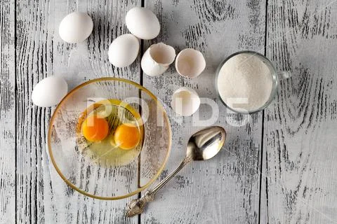 Separated egg white and yolks into two bowls and broken egg shells are at b.. Stock Photos