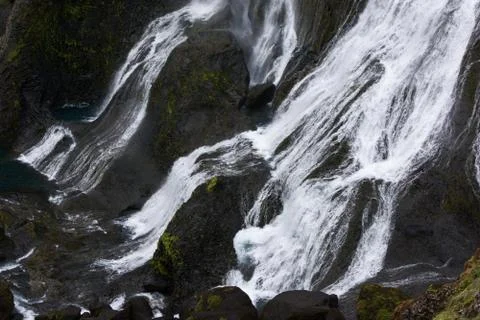 Separated streams of a waterfall running on black rocks, iceland Stock Photos