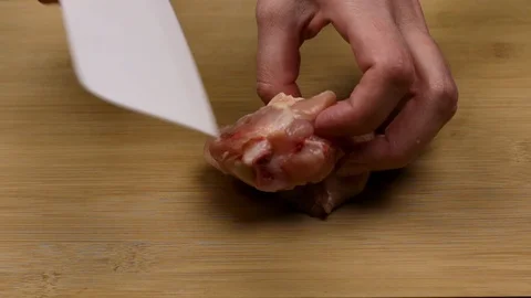 Separating chicken meat from bone for making fillets and cutting and slicing as Stock Footage 107510669