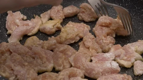 Separating chicken meat chunks from one another on a hot frying pan 库存影片 290090252