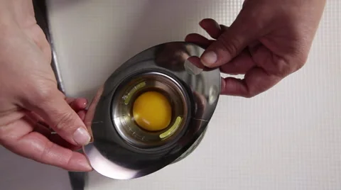 Separating an egg using an egg separator; top-shot Stock Footage 64026948
